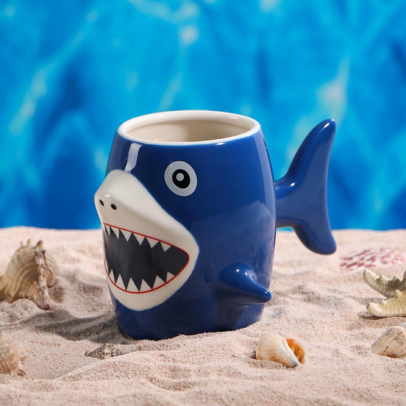Blue 3D shark ceramic mug 450ml on beach lifestyle shot - Form Feast