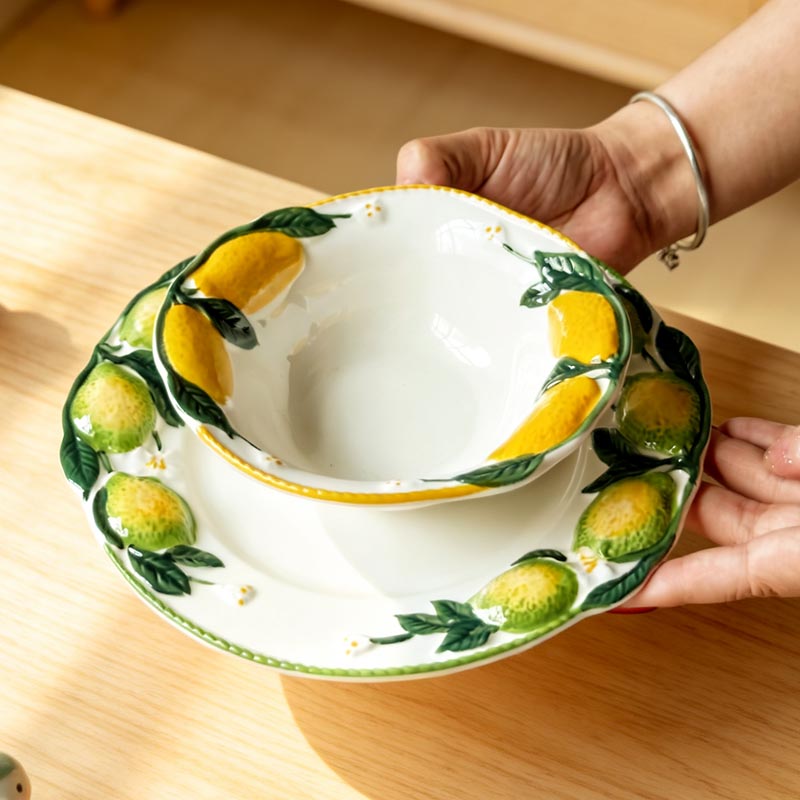 Hand-painted lemon ceramic bowl held by hand - Form Feast