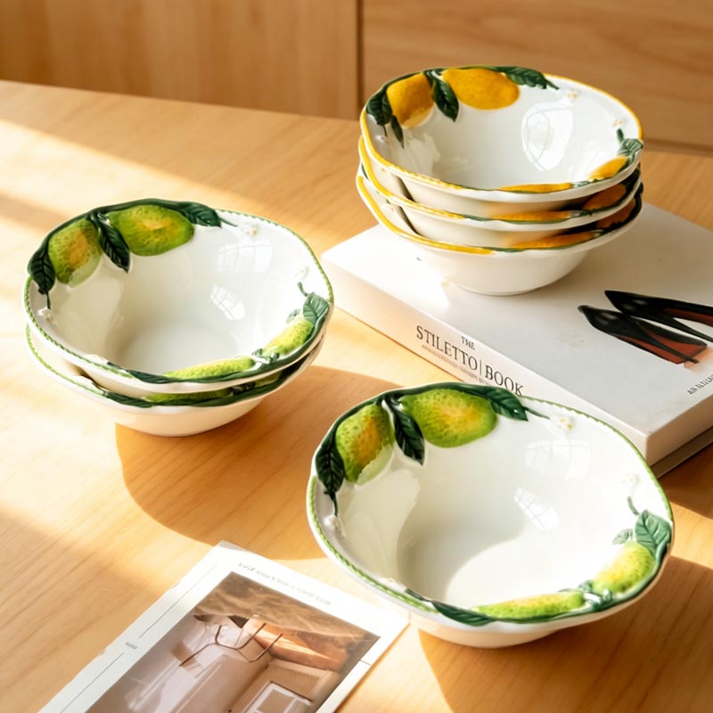 Hand-painted lemon ceramic bowls on table with book - Form Feast